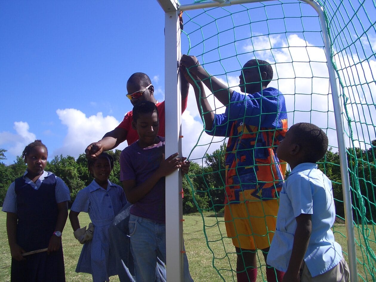 Befestigen des Netzes am Tor von Jugendlichen auf Barbados