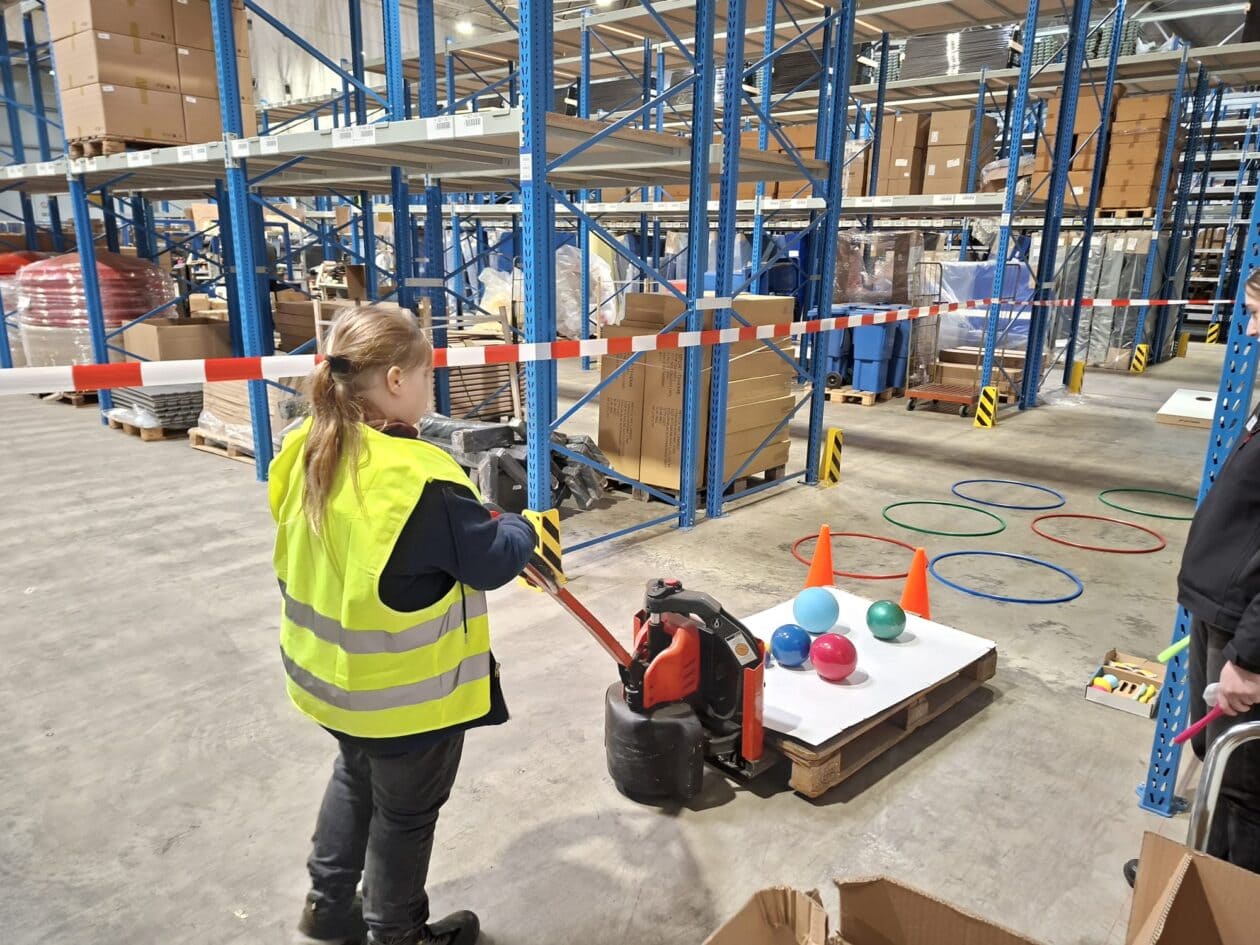 Student testing a pallet truck course in the Sport-Thieme logistics center.
