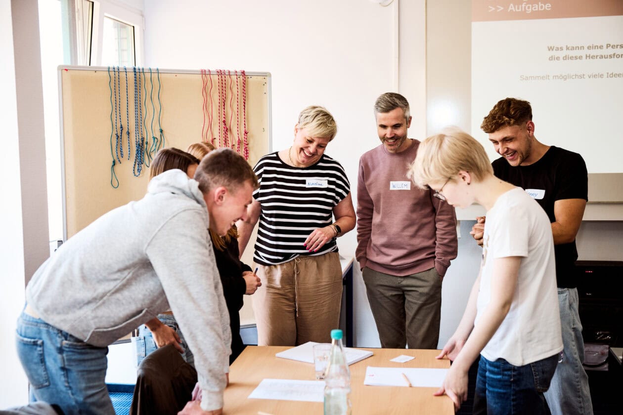 Auszubildende und Ausbildungsverantwortliche von Sport-Thieme bei einer interaktiven Teamübung zur Förderung von Kommunikation und Zusammenarbeit.