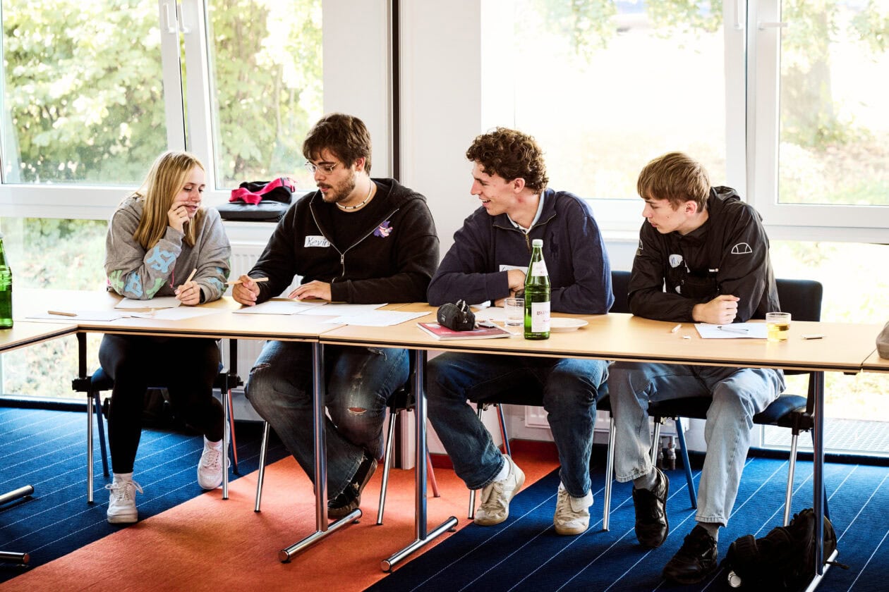 Sport-Thieme Auszubildende arbeiten gemeinsam an einer Gruppenaufgabe während eines Workshops auf der Azubifahrt.